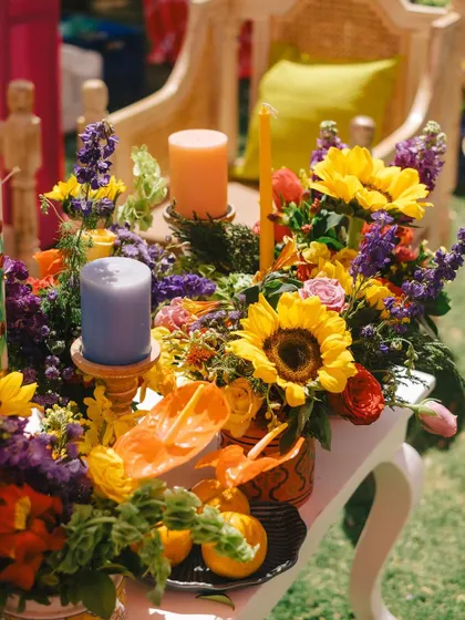 A vibrant arrangement of sunflowers, purple statice, and orange anthuriums, creating a beautiful explosion of color.
