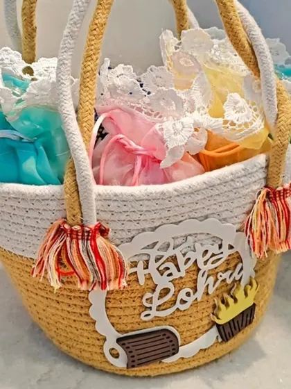A yellow and white version of the Lohri hamper basket, filled with colorful potlis.