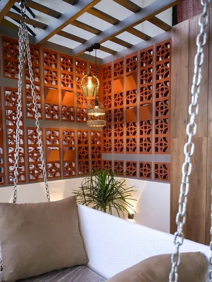We created this cozy and private corner on a balcony using terracotta jali walls. The space is perfect for a swing, offering a secluded spot to unwind, surrounded by beautiful patterns and textures.