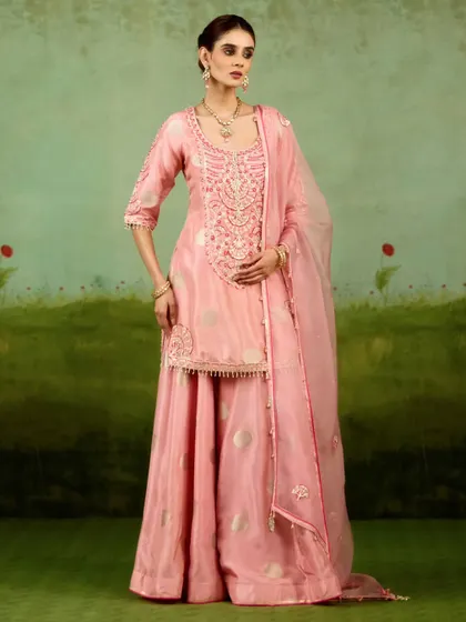 Playful yet refined, this soft pink sharara set brings modern ease to festive elegance. With its fluid lines, intricate zardozi work on the kurta, and hand-finished details, it is a perfect choice for a daytime celebration.