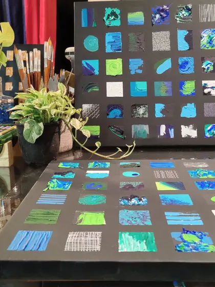 In-progress canvases for the blue and green grid installation, showing the exploration of different textures, brushstrokes, and patterns.