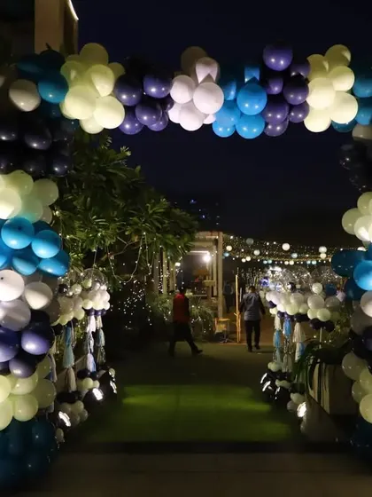 A grand balloon arch at the entrance of the party. The mix of dark blue, light blue, white, and lime green balloons created a festive and inviting walkway for guests.