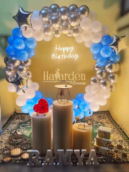 A blue and silver balloon ring with a 'Happy Birthday' neon sign, perfect for a modern and stylish party.