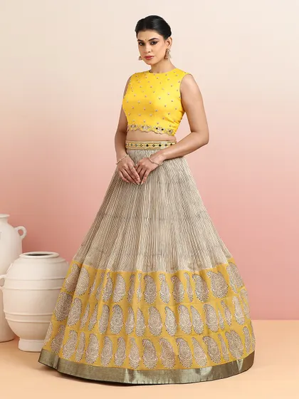 The full view of the yellow blouse with the beige paisley lehenga, a soft and elegant option for daytime events.