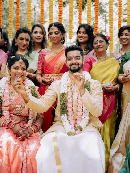 A happy family portrait with the couple at the center, taken during their beautiful outdoor wedding ceremony.