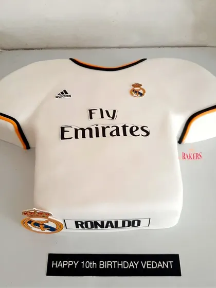 A custom Real Madrid jersey cake for a young football fan's 10th birthday. I handcrafted this cake to look just like Ronaldo's iconic jersey, complete with the logos and sponsors. It's a dream come true for any fan.