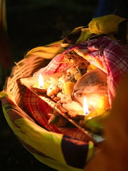 A basket of offerings, or 'soop', lit with diyas for Chhath Puja. It contains fruits, sweets, and other items to be offered to the Sun God.