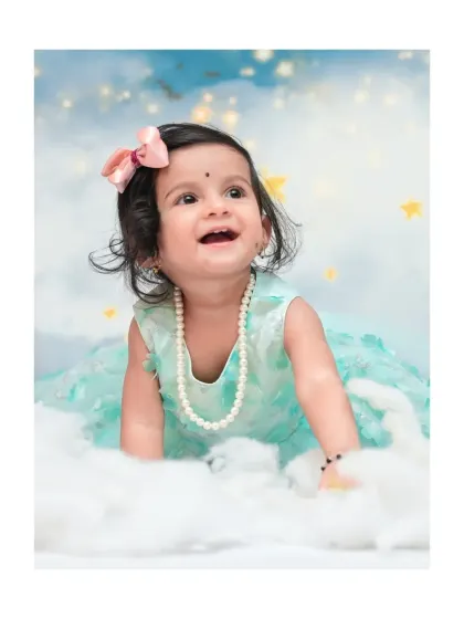 A close-up from a 'Moon & Stars' session, showing a beautiful, happy expression. I focus on capturing these sweet, fleeting moments of wonder against a dreamy, cloud-like backdrop.