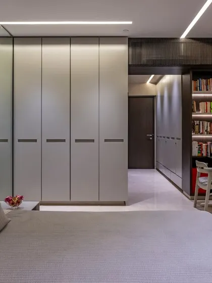 A view from the bed, this image shows the seamless integration of the wardrobe and a compact study nook with a bookshelf. The design maximizes space without sacrificing style.