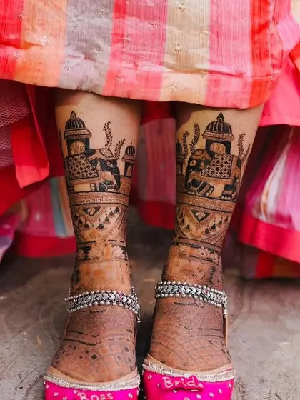 Bridal feet mehandi paired with custom "Bride" juttis. This photo shows how our designs complement your entire bridal look, right down to the shoes.