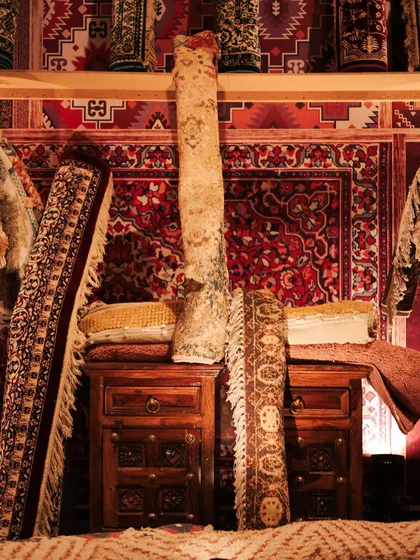 A detail from the rug market, with rolled carpets stacked on wooden chests. The variety of patterns and textures created a visually rich and authentic display.