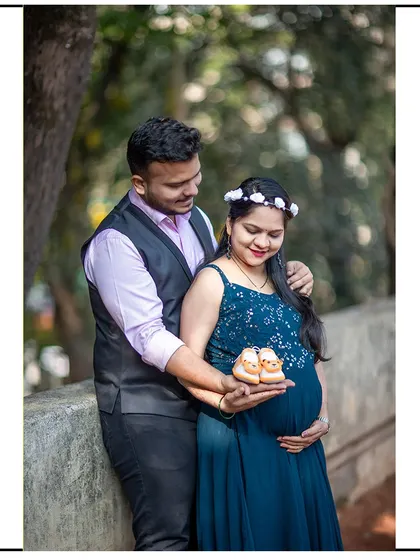 A proud couple shows off a pair of tiny baby shoes, ready to welcome their new arrival.