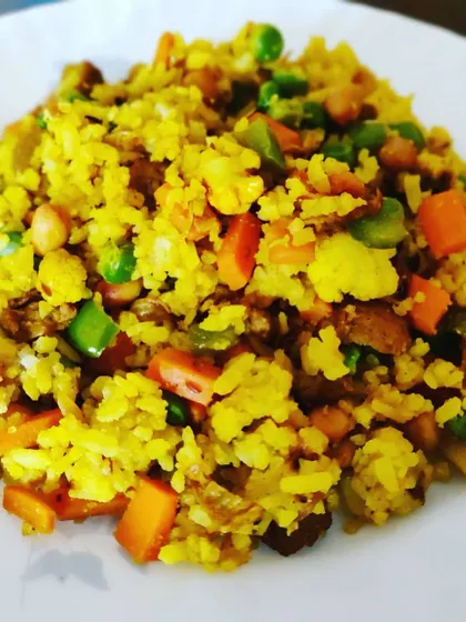 A plate of Maharaja Poha, a nutritious and flavorful breakfast dish packed with fresh vegetables like carrots, peas, and cauliflower.