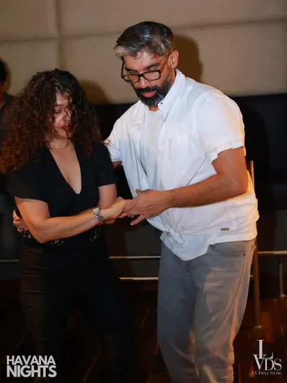 A moment of concentration and connection between two dancers. You can see the lead guiding his partner through a move, highlighting the non-verbal communication of partner dancing.