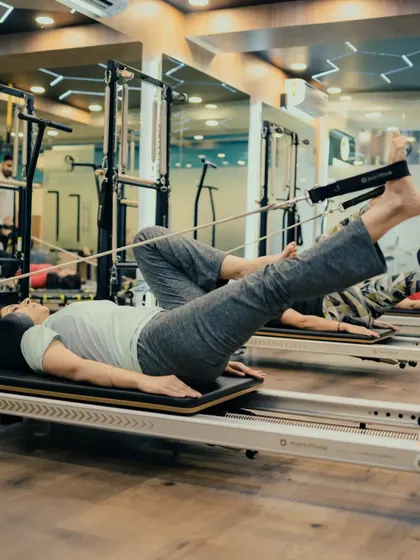 This exercise on the Reformer strengthens the core and improves hip mobility. The client maintains a stable torso while moving her legs against resistance.