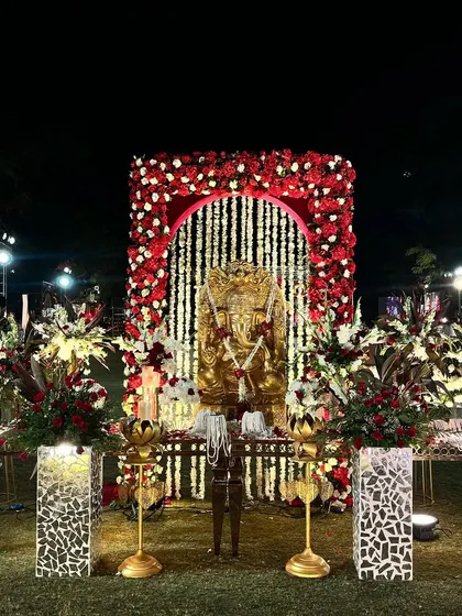 A sacred corner for the Ganesh puja, framed by a floral arch of red and white. It's important to create dedicated, beautifully decorated spaces for all the important rituals of the wedding.