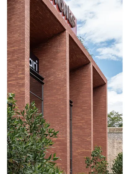 A close-up of the brickwork on the Clayworks building, showing the texture and depth of the facade. The deep recesses of the window bays create a strong sense of solidity and permanence.