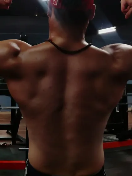 Progress is a journey. Here I'm assessing my lower back, identifying areas to improve. My coaching is transparent, and we will work together to cut fat and build muscle.