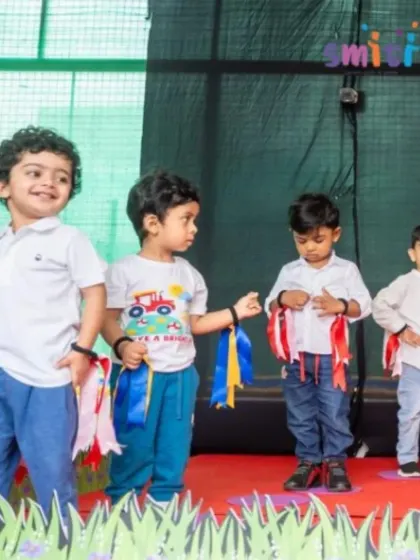 Boys perform on stage with colorful ribbons tied to their wrists. Their smiles show the pure fun they have during these performances.