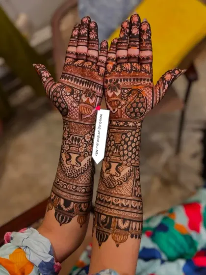 This full-arm bridal design showcases a mix of traditional Indian motifs, including peacocks and floral paisleys. The patterns are dense and detailed, perfect for a bride.