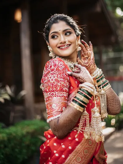 A joyful portrait of the bride, her hands adorned with mehndi and traditional green bangles.