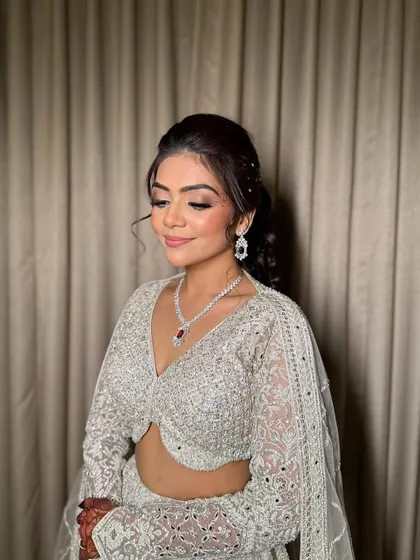 A close-up with eyes closed, detailing the soft, shimmery eyeshadow work that gives this sangeet look its glamour.