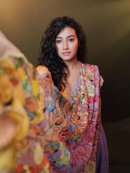 A creative shot using the flowing fabric to frame the model's face, adding depth and a sense of mystery.