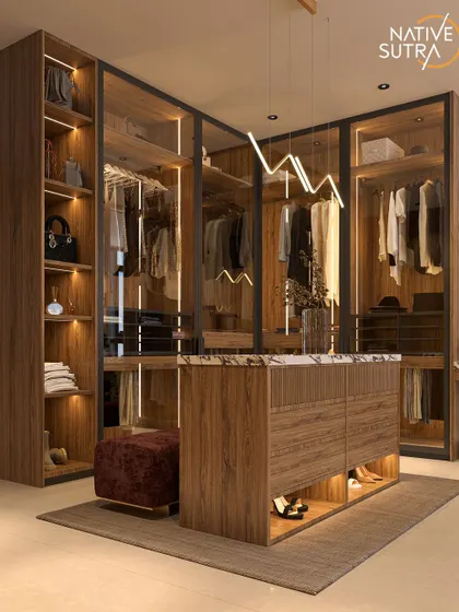 Welcome to a walk-in oasis. This dressing room features custom-built, glass-fronted wardrobes with integrated lighting, a central island with storage, and a dedicated vanity area for a truly luxurious experience.