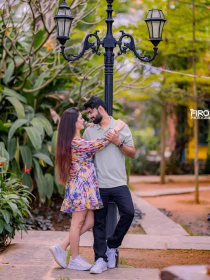A romantic pose by a vintage-style lamppost. The couple's casual outfits look stylish and modern in this classic, romantic setting.