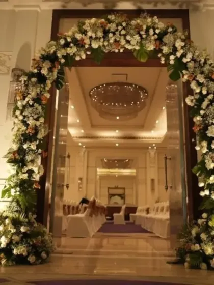 Make a grand entrance to your wedding. This magnificent floral arch, made of white flowers and lush greenery, creates a stunning entryway for the couple and their guests.