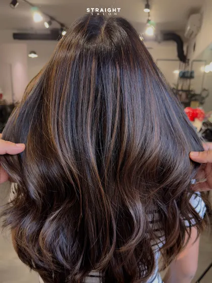A full view of this dream makeover, with a stylist holding up the hair to show its fullness and health.