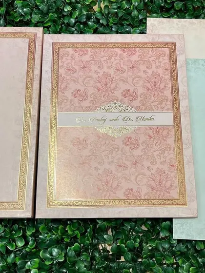 A beautiful invitation set in pastel pink and blue, with delicate floral patterns and gold foil borders.