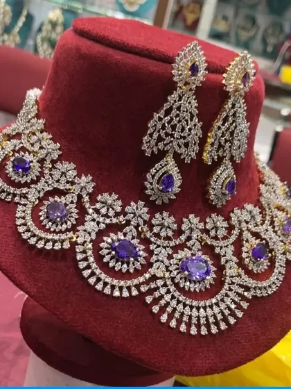A grand choker necklace with a web of CZ stones and purple stone accents. This piece is designed to be the centerpiece of your reception or sangeet look.