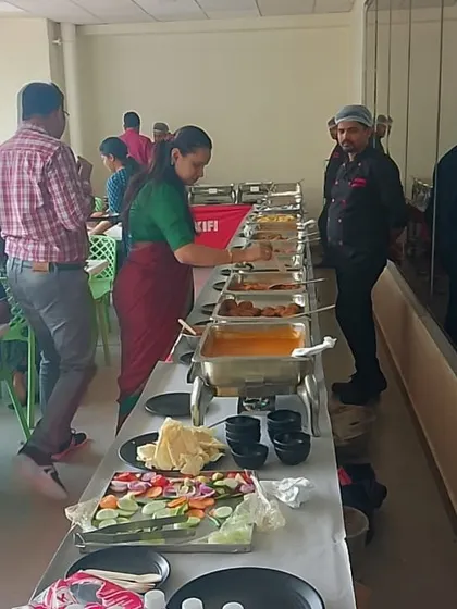 Our staff ensuring the buffet line is clean and well-maintained during a busy lunch service for a corporate client.