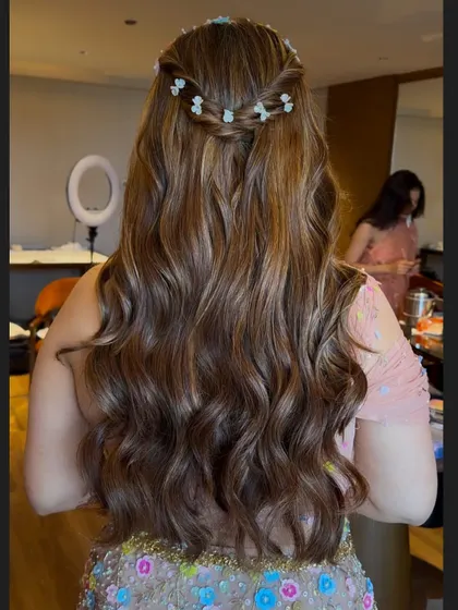 A close-up of the wavy hairstyle, showing the texture and the pretty floral braid detail.