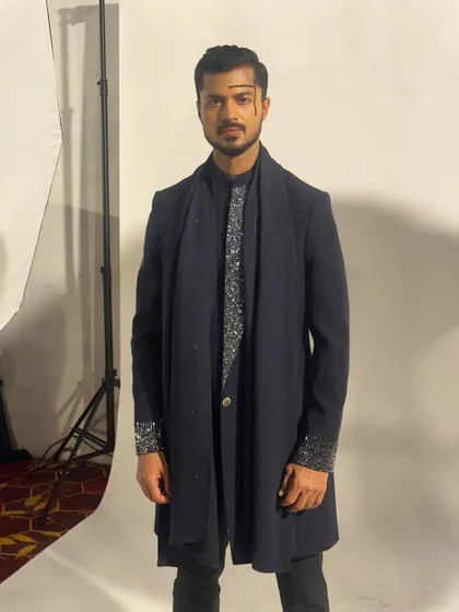 A final look before walking the ramp, ensuring every element of the outfit is perfectly in place.