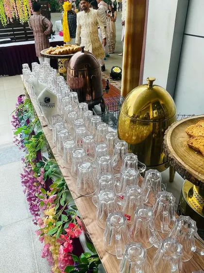 A fully stocked tea and coffee bar ready for service. We ensure everything is neatly arranged, from the glasses to the branded napkins, reflecting our professional approach.