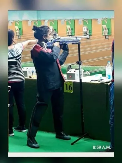 A student competing at the UP State Shooting Championship, showing excellent form with her air rifle.