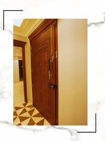 This solid, paneled wooden door with classic hardware is where dreams find their truest expression. It’s a detail that speaks of quality, security, and timeless style.