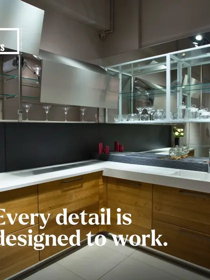 Here, we've used open glass shelving and lift-up cabinets to create a bar area within the kitchen, combining display and function.