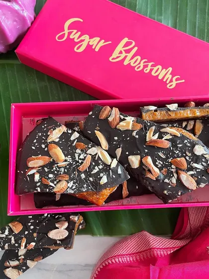 A perfect Diwali gift, this box contains my crisp roasted almond toffee bark. The crunchy toffee is covered in dark chocolate and sprinkled with toasted almonds, offering an irresistible combination of sweet and nutty flavors.