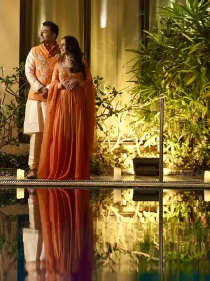 A beautiful reflection shot of the couple standing by the pool during their pre-wedding event.