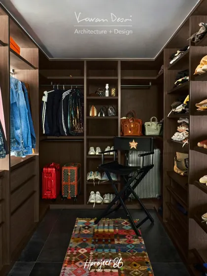 The walk-in wardrobe for Project 86. We designed it with custom shelving for shoes, bags, and clothes, ensuring every item has its place. The colorful rug adds a personal touch.