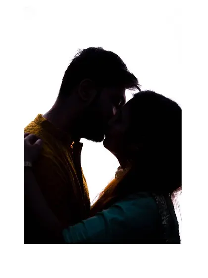 A beautiful silhouette of a kiss. This artistic pre-wedding shot focuses on the form and emotion of the moment, creating a timeless and romantic image.