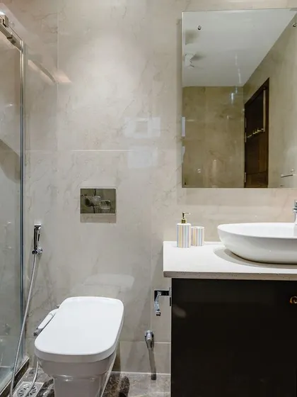A sophisticated bathroom design that mixes dark and light tones. The dark vanity provides a beautiful contrast to the light marble tiles.