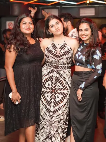A stylish group of friends posing for a photo, enjoying the club's atmosphere.