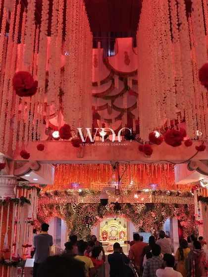 The interior of the temple, with a ceiling adorned with cascading strings of white flowers and red floral balls, creating a breathtaking and spiritual atmosphere.