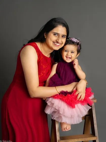 A mother and daughter sharing a laugh. Their joyful interaction and coordinating outfits make this a heartwarming and beautiful portrait.