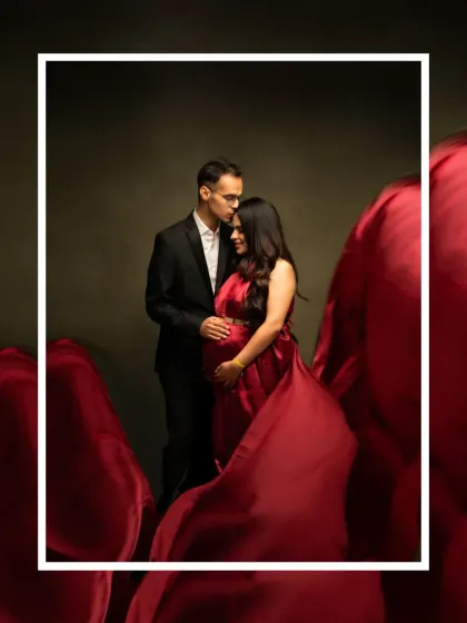 A romantic and dramatic couple's portrait. The flowing red fabric envelops the couple, creating an intimate and artistic image that focuses on their connection and anticipation.
