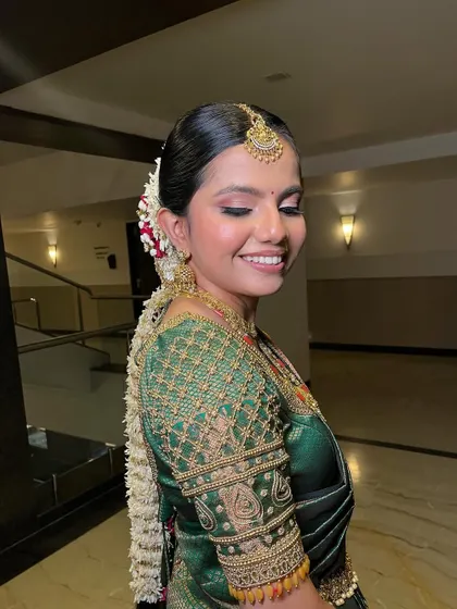 A side profile showcasing the intricate floral braid and the soft, glowing makeup. The look is a perfect blend of tradition and modern elegance.